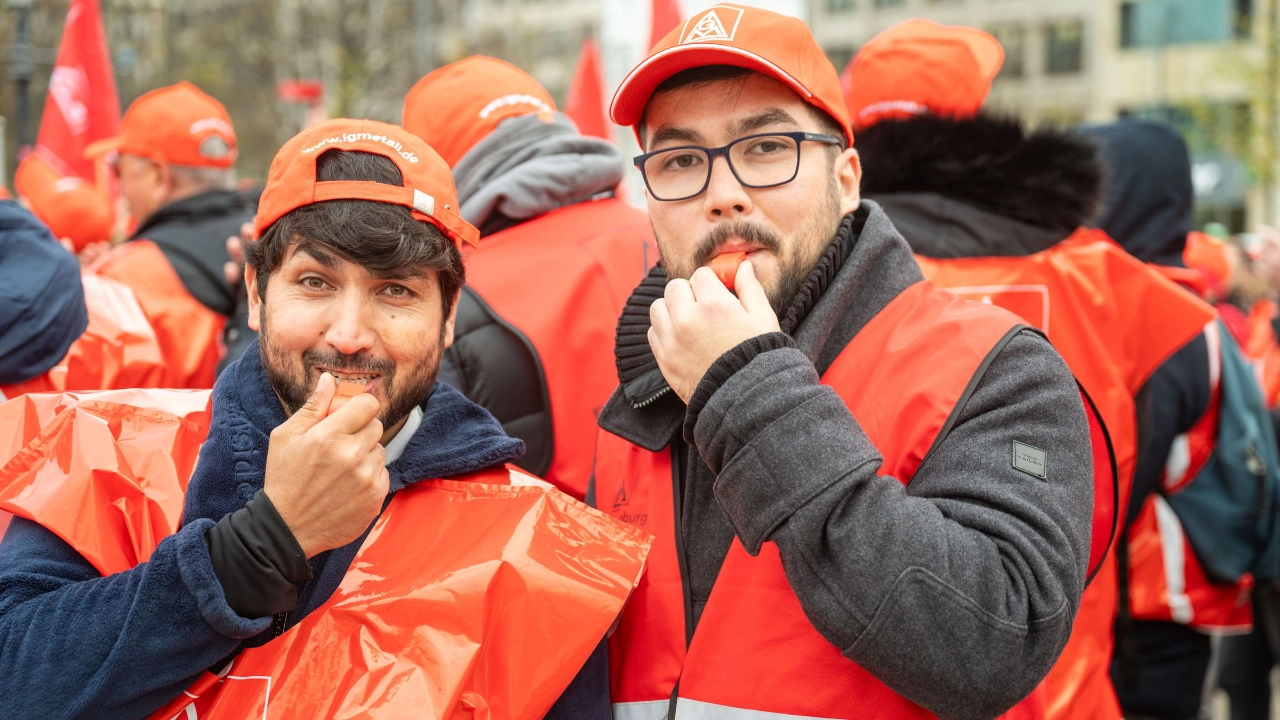 Zwei Männer mit Trillerpfeife bei einem Warnstreik der VW-Tochter MOIA