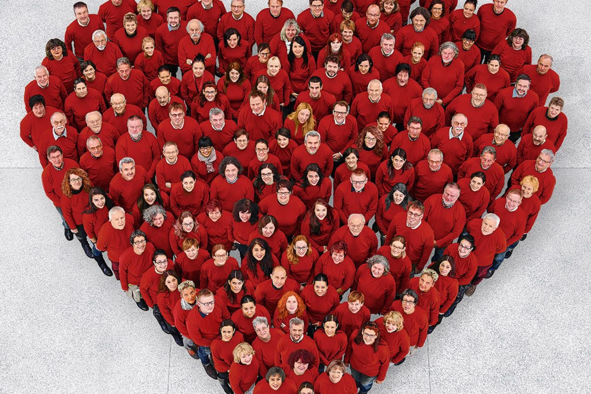 Beschäftigte stehen zu einem großen Herz zusammen