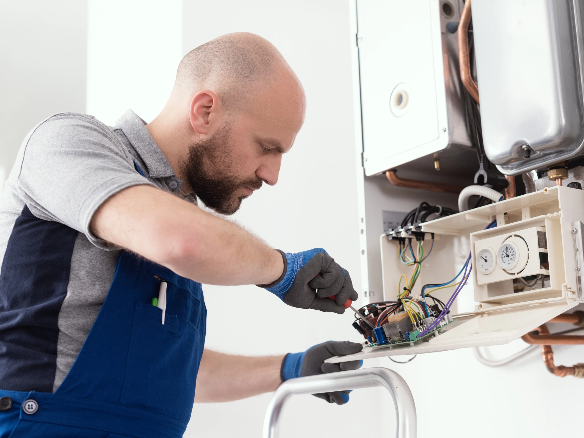 Anlagenmechaniker wartet einen Heizungskessel